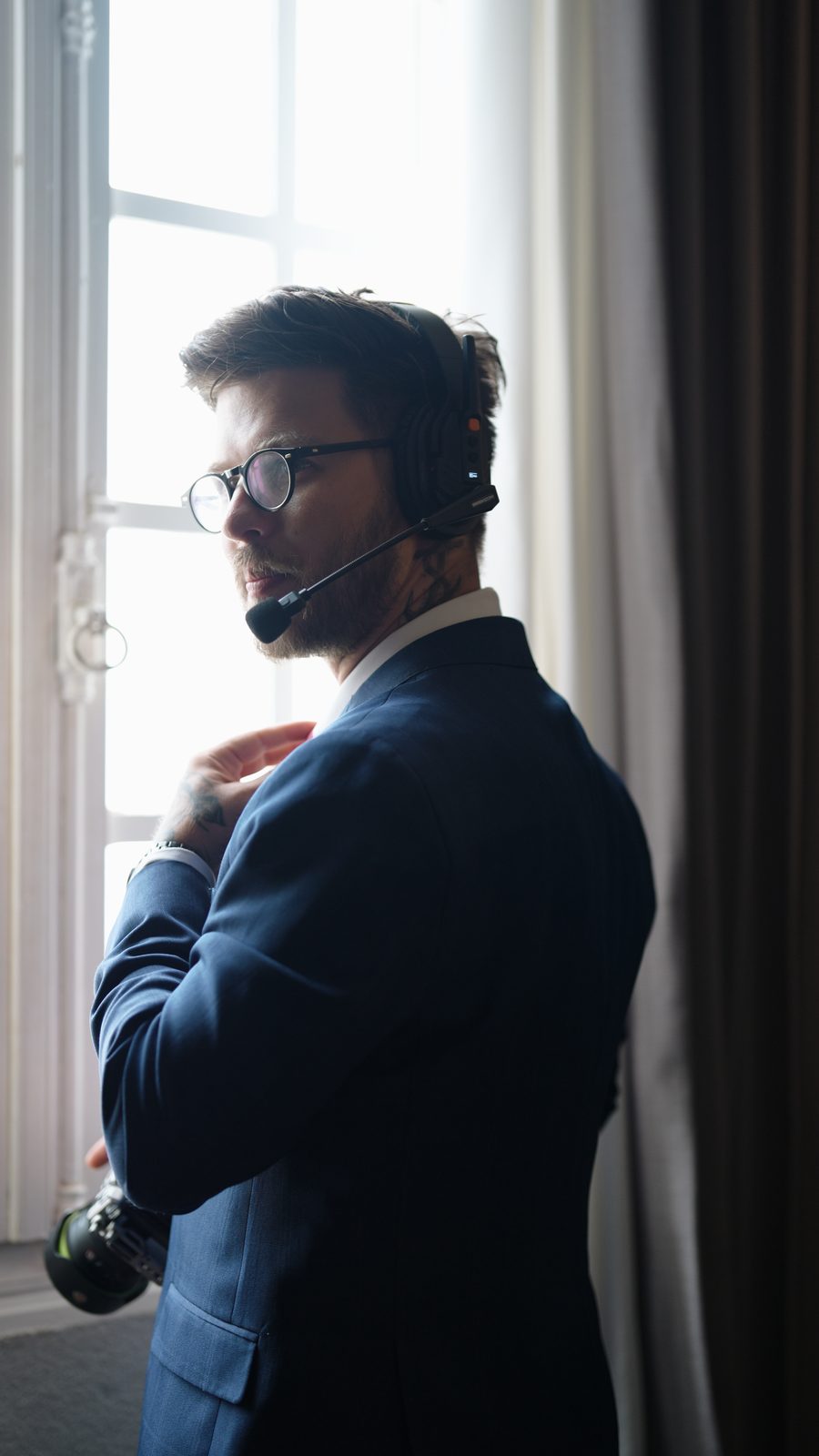 Cinegrafista com headset de comunicação junto à janela
