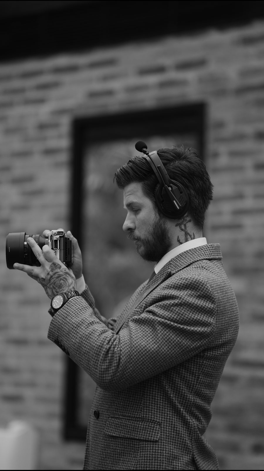 Cinegrafista de perfil filmando com câmera na mão